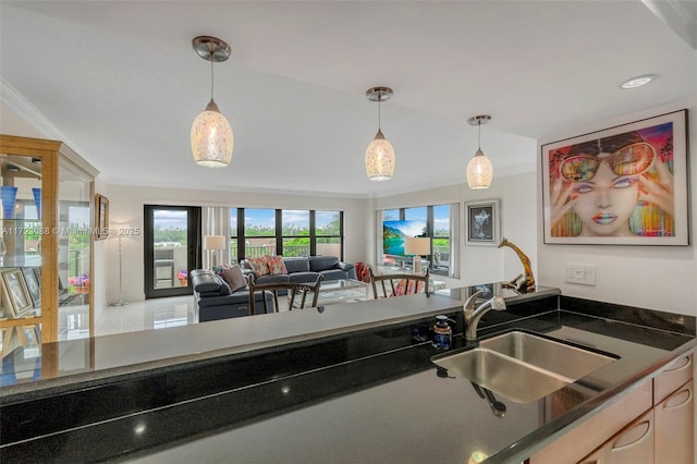 kitchen featuring sink, pendant lighting, and ornamental molding