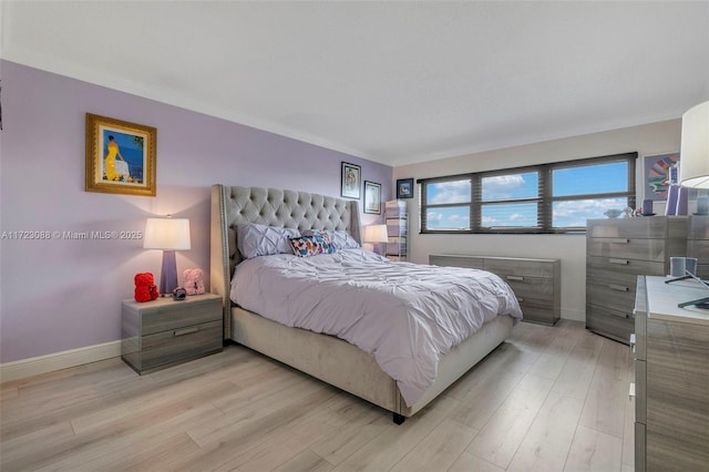 bedroom with light hardwood / wood-style floors and crown molding