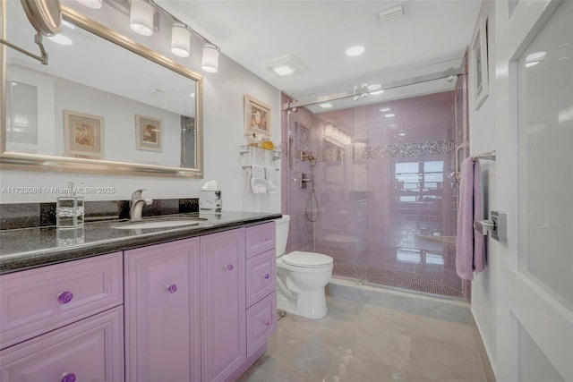 bathroom featuring vanity, toilet, and a shower with door