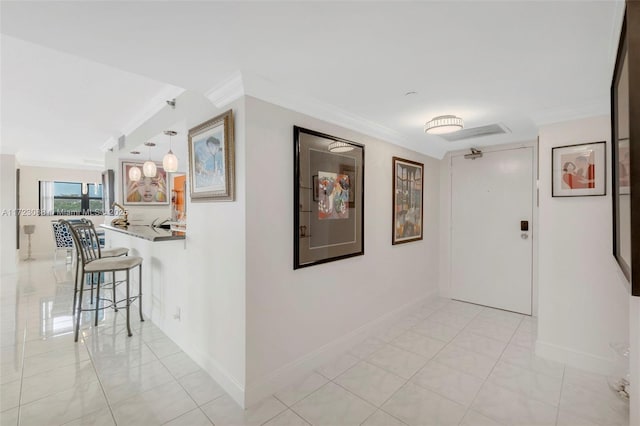 corridor featuring light tile patterned floors and crown molding