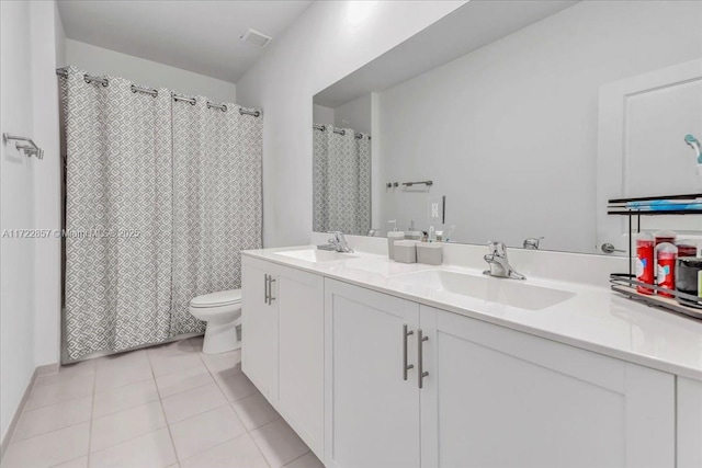 bathroom with tile patterned flooring, vanity, and toilet