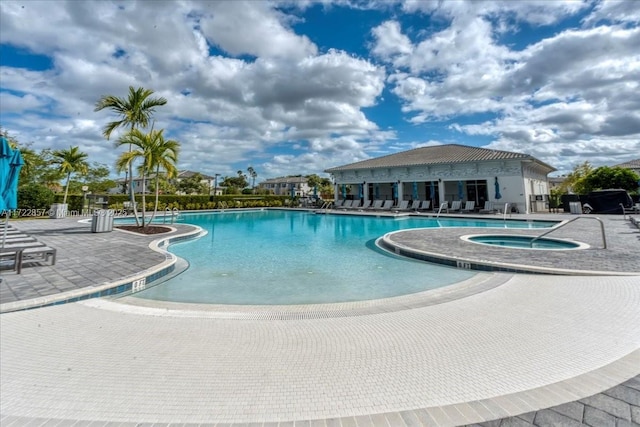 view of pool featuring a hot tub and a patio area