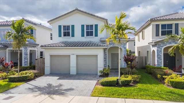 mediterranean / spanish-style home featuring a garage and a front yard