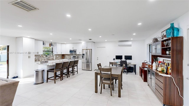 dining room with an AC wall unit and sink