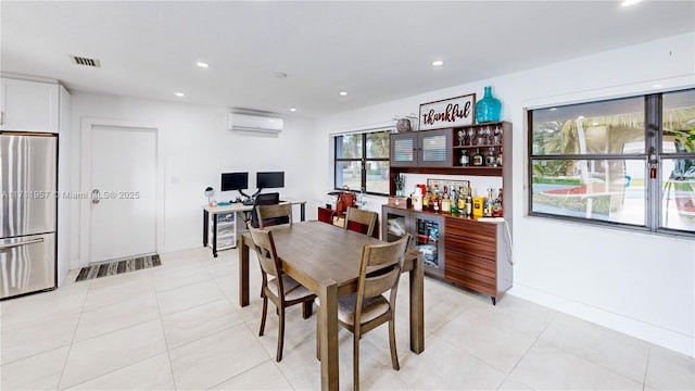 dining room featuring light tile patterned flooring and a wall unit AC