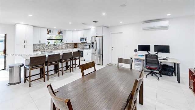 tiled dining space with a wall unit AC and sink