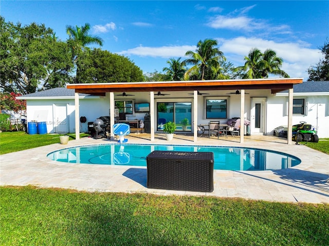 view of swimming pool featuring a lawn, ceiling fan, and a patio area