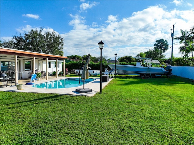 view of swimming pool with a lawn, a patio area, and ceiling fan