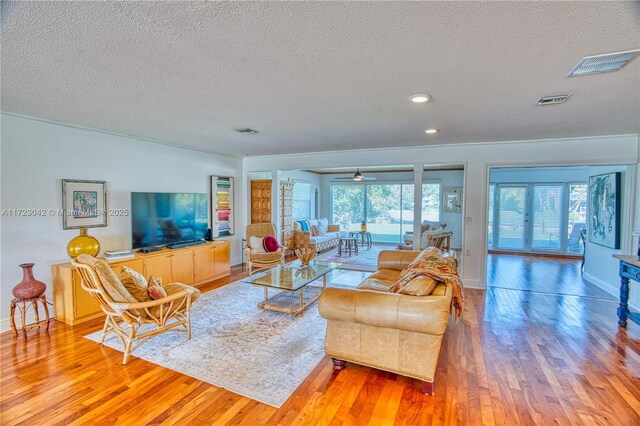 living area featuring light wood-style floors, visible vents, and french doors