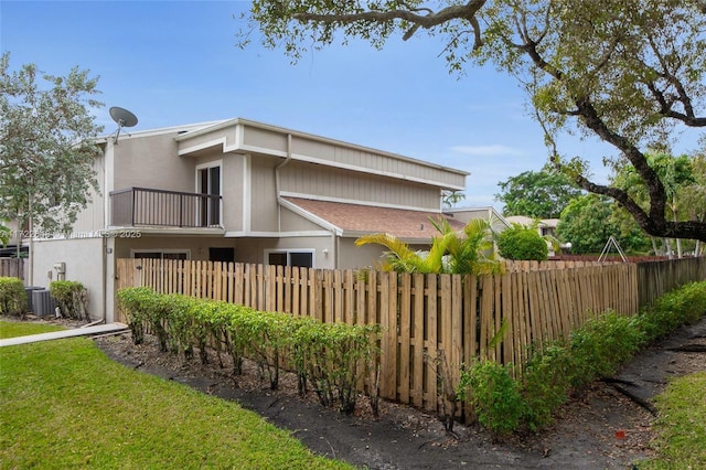 view of home's exterior with central AC and a balcony