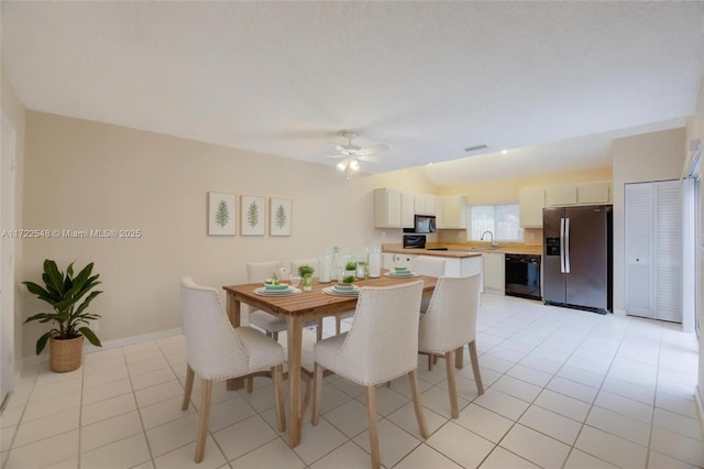 dining room featuring ceiling fan, sink, and light tile patterned floors