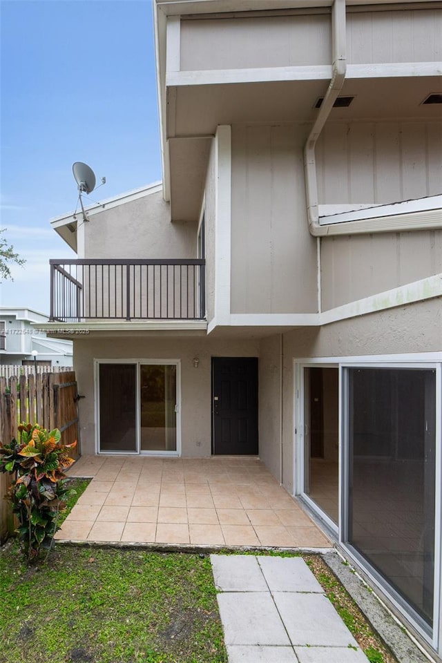 back of property featuring a balcony and a patio