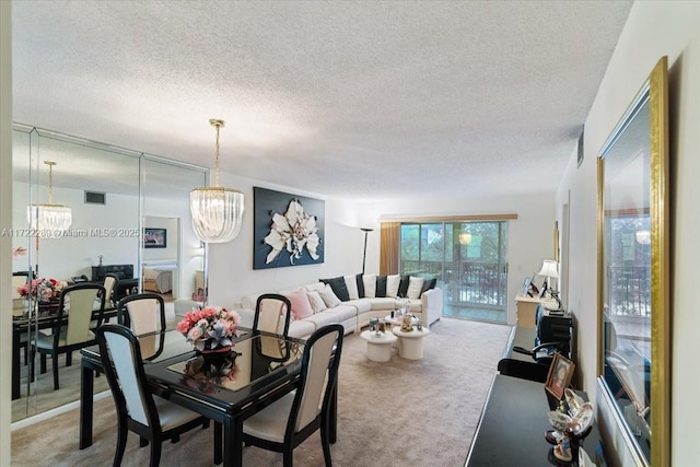 dining area with a chandelier, carpet, and a textured ceiling