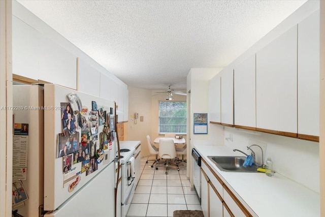 kitchen featuring white appliances, ceiling fan, sink, light tile patterned floors, and white cabinetry