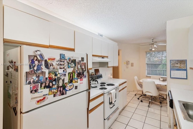 kitchen featuring white appliances, white cabinets, ceiling fan, light tile patterned floors, and a textured ceiling