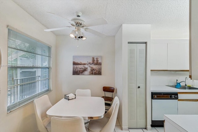 tiled dining area featuring ceiling fan, plenty of natural light, a textured ceiling, and sink