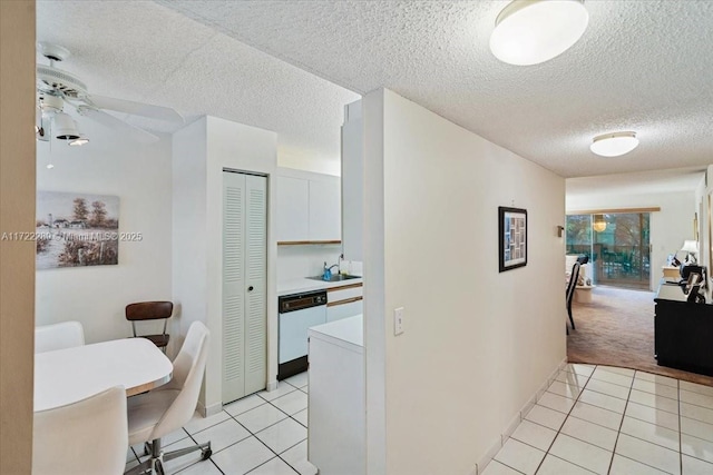 hall featuring a textured ceiling, sink, and light tile patterned flooring