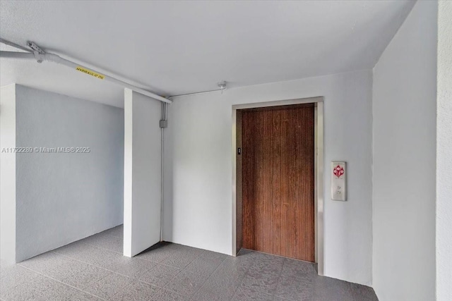 unfurnished room with elevator