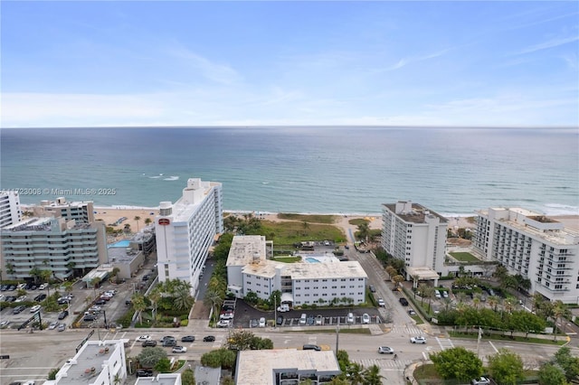 drone / aerial view featuring a water view and a view of the beach