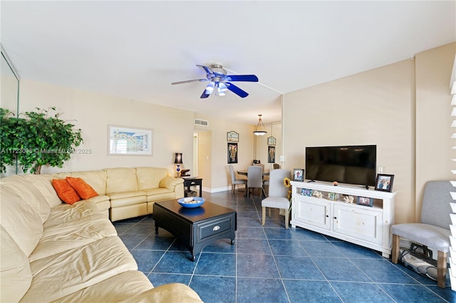 living area featuring visible vents, ceiling fan, dark tile patterned floors, and baseboards