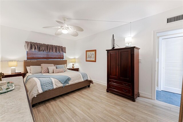 bedroom with a ceiling fan, visible vents, light wood-style flooring, and baseboards