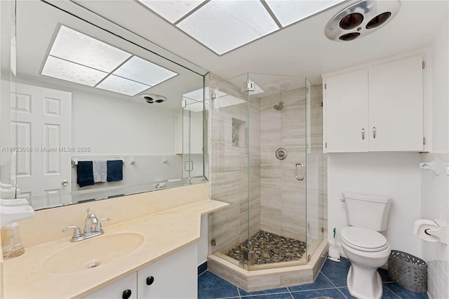 bathroom with toilet, tile patterned floors, walk in shower, and vanity