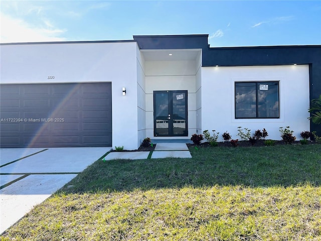 view of front of property with a garage and a front lawn