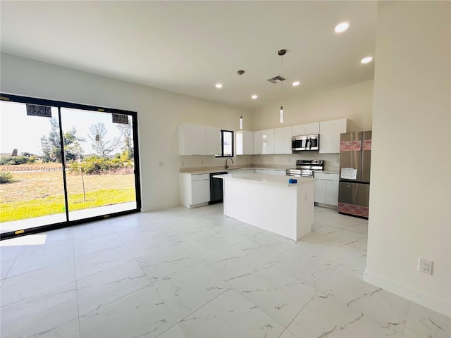 kitchen with sink, a center island, pendant lighting, stainless steel appliances, and white cabinets