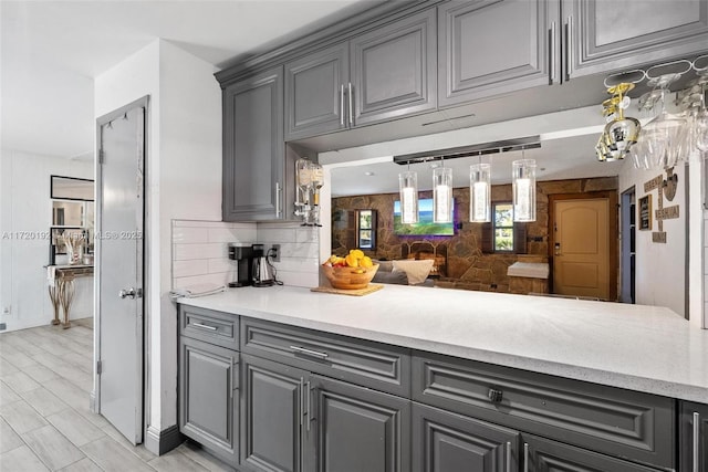 kitchen featuring tasteful backsplash and gray cabinets