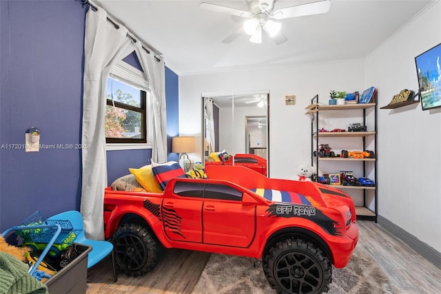 bedroom featuring hardwood / wood-style floors, ceiling fan, and crown molding