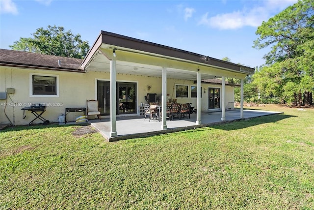 rear view of house with a lawn and a patio