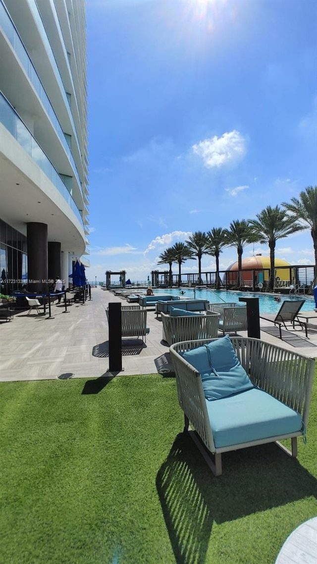 view of community featuring a yard, a patio, and a pool