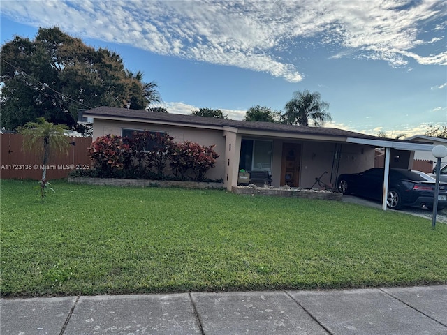 ranch-style home with a front yard and a carport