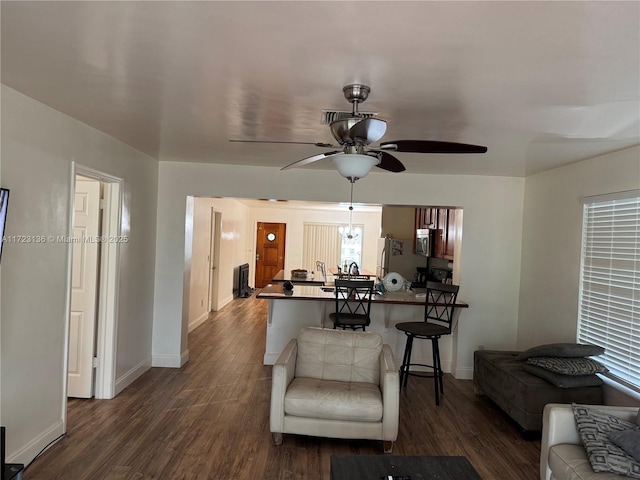 living room with ceiling fan and dark wood-type flooring