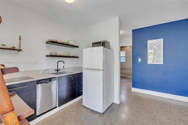 kitchen featuring dishwasher, white refrigerator, and sink