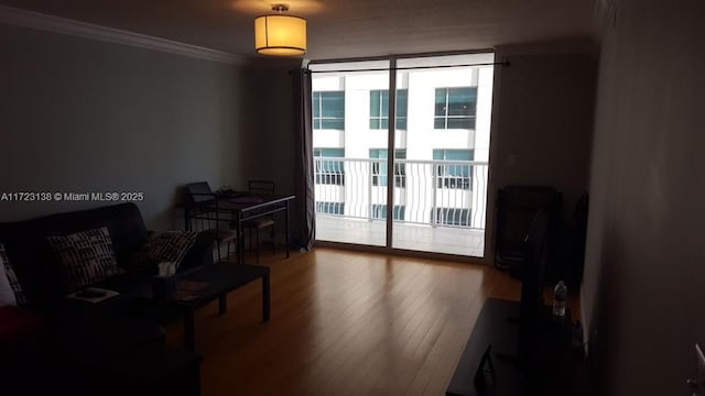 living room featuring wood-type flooring, expansive windows, and crown molding