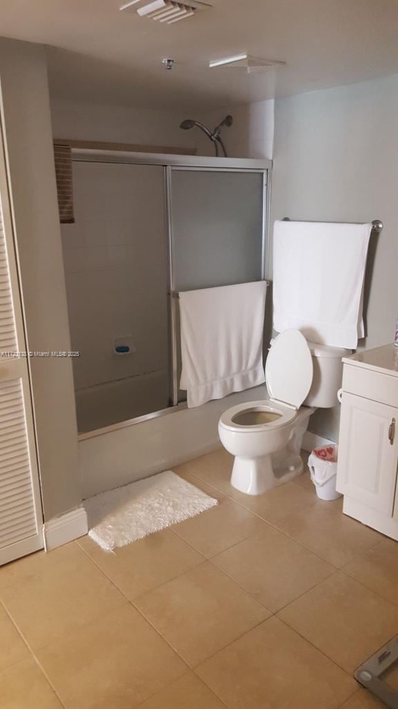 full bathroom featuring tile patterned flooring, vanity, toilet, and combined bath / shower with glass door