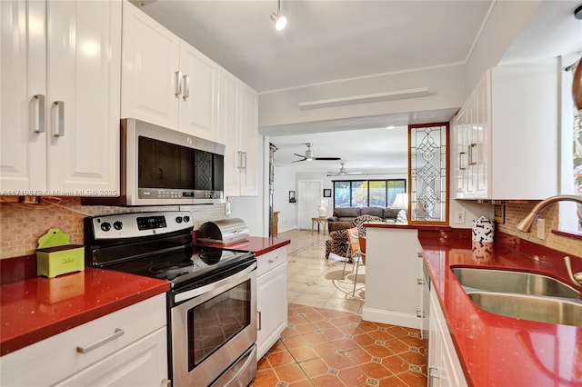 kitchen with white cabinetry, ceiling fan, appliances with stainless steel finishes, tasteful backsplash, and sink