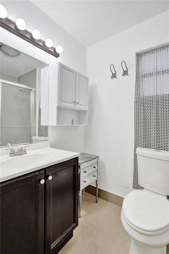 bathroom with a shower with shower door, toilet, vanity, and tile patterned flooring