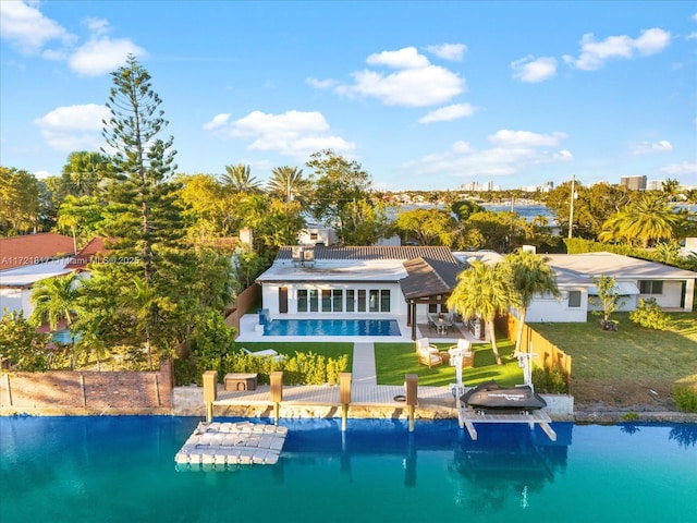 rear view of property featuring a yard, a water view, a patio area, and a balcony