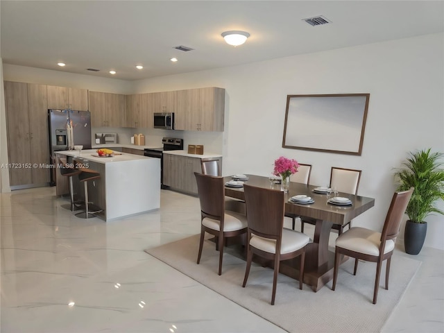 kitchen with a kitchen island, a kitchen bar, and stainless steel appliances