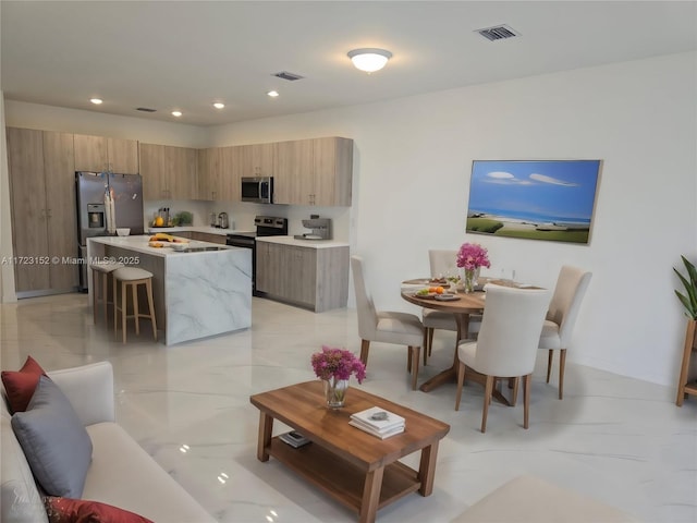 kitchen with a kitchen breakfast bar, a kitchen island, and stainless steel appliances