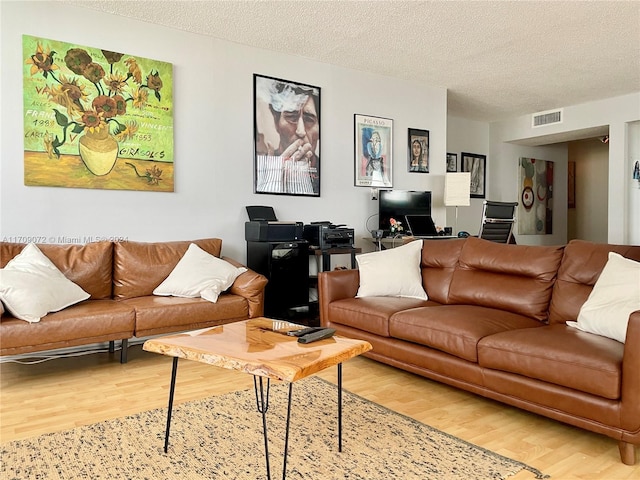 living room with hardwood / wood-style floors and a textured ceiling