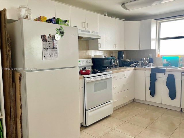 kitchen with white cabinets, white appliances, sink, and light tile patterned floors