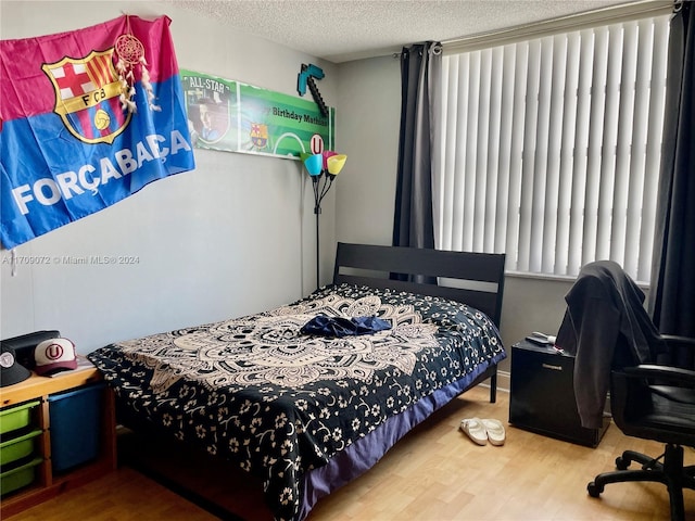 bedroom featuring hardwood / wood-style floors and a textured ceiling