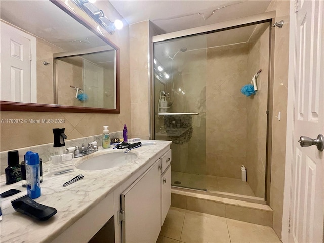 bathroom with tile patterned flooring, vanity, and walk in shower