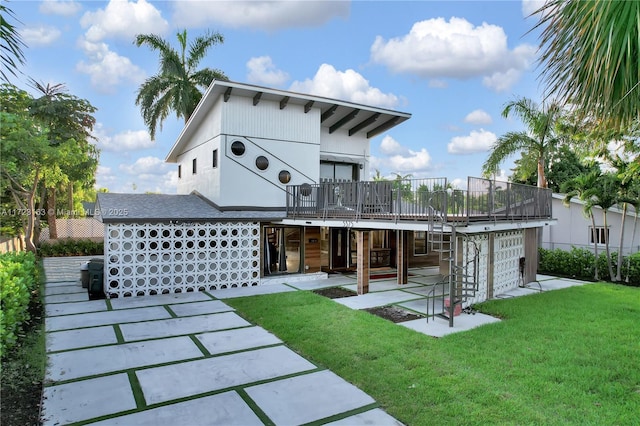 rear view of property featuring a lawn and a patio