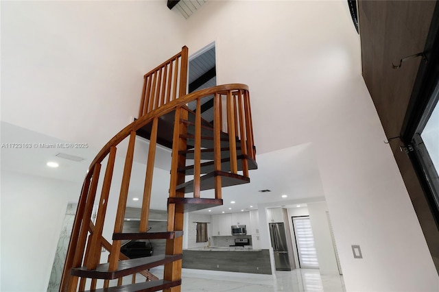 staircase featuring a high ceiling