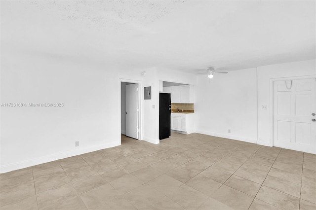 tiled spare room featuring ceiling fan, a textured ceiling, and electric panel