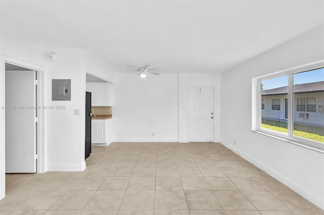 empty room featuring ceiling fan, light tile patterned floors, and electric panel